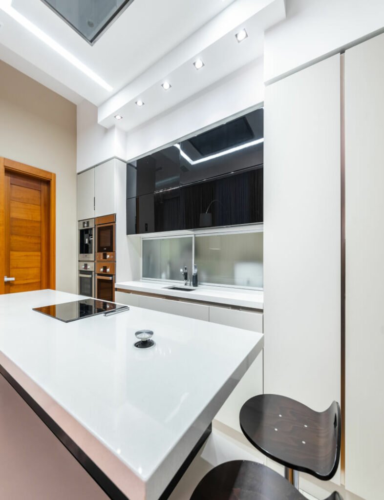 A modern kitchen with a white island and stools.